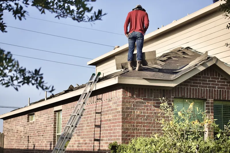 Professional roofer working on a residential roof in Olney